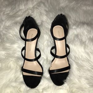 Black three strap open toe heels.